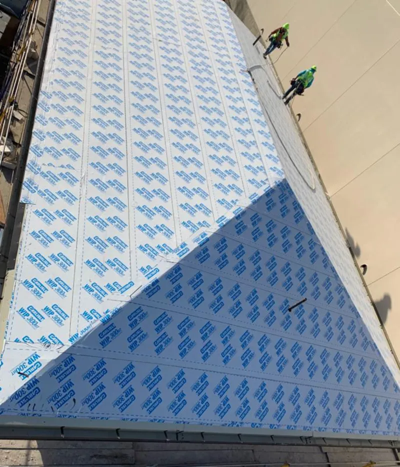 Professional roofers installing underlayment on a metal roof in Bel Air North